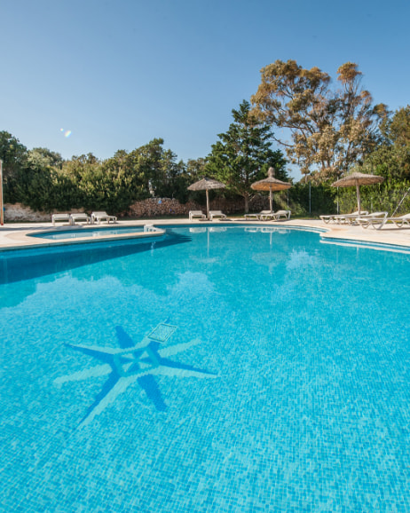 Piscina con sombrillas y hamacas